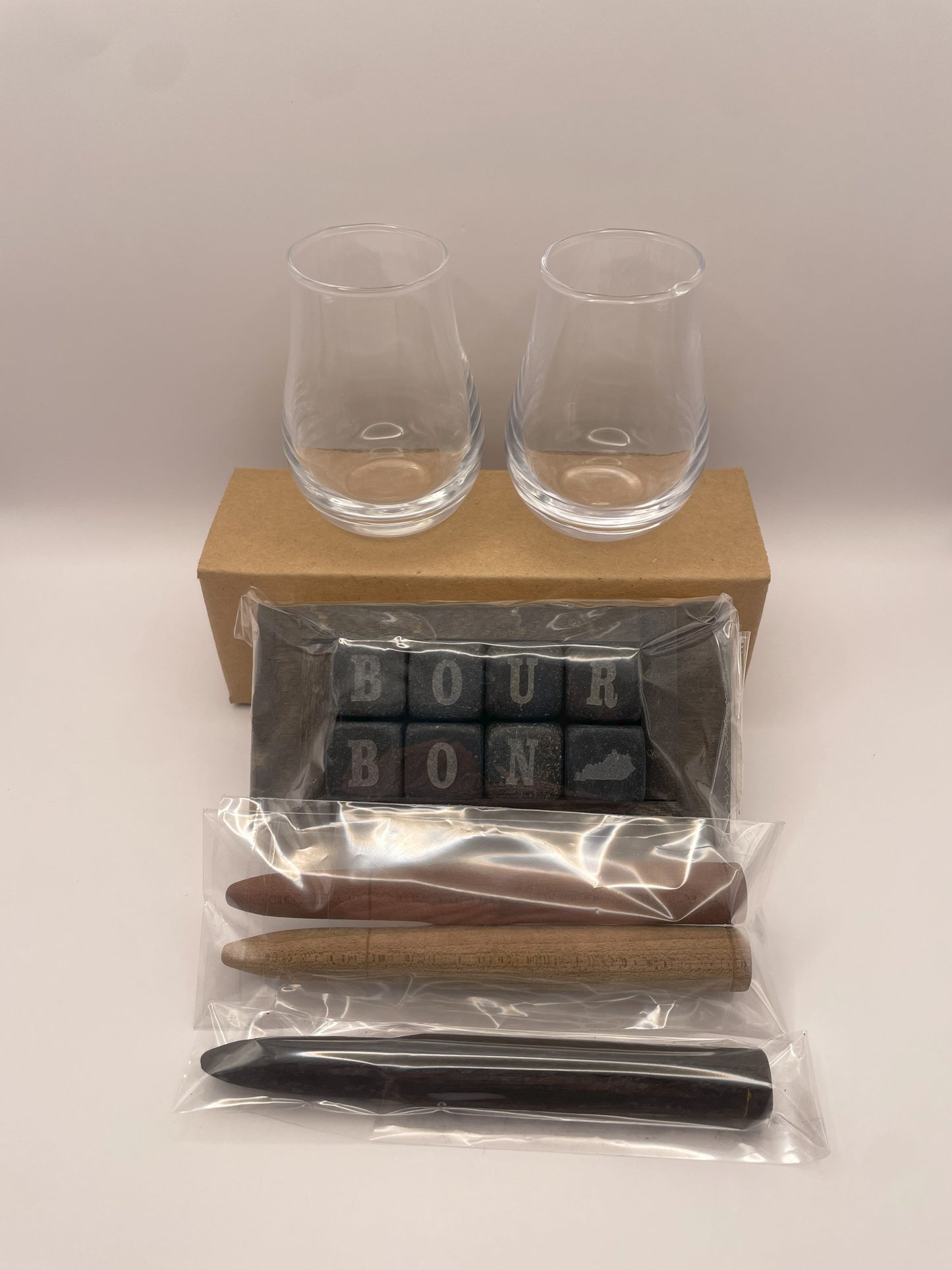 A Bourbon rocks and stave gift box is shown, featuring two elegant tasting glasses and bourbon smoothing and aging infusion staves for enhancing your bourbon.