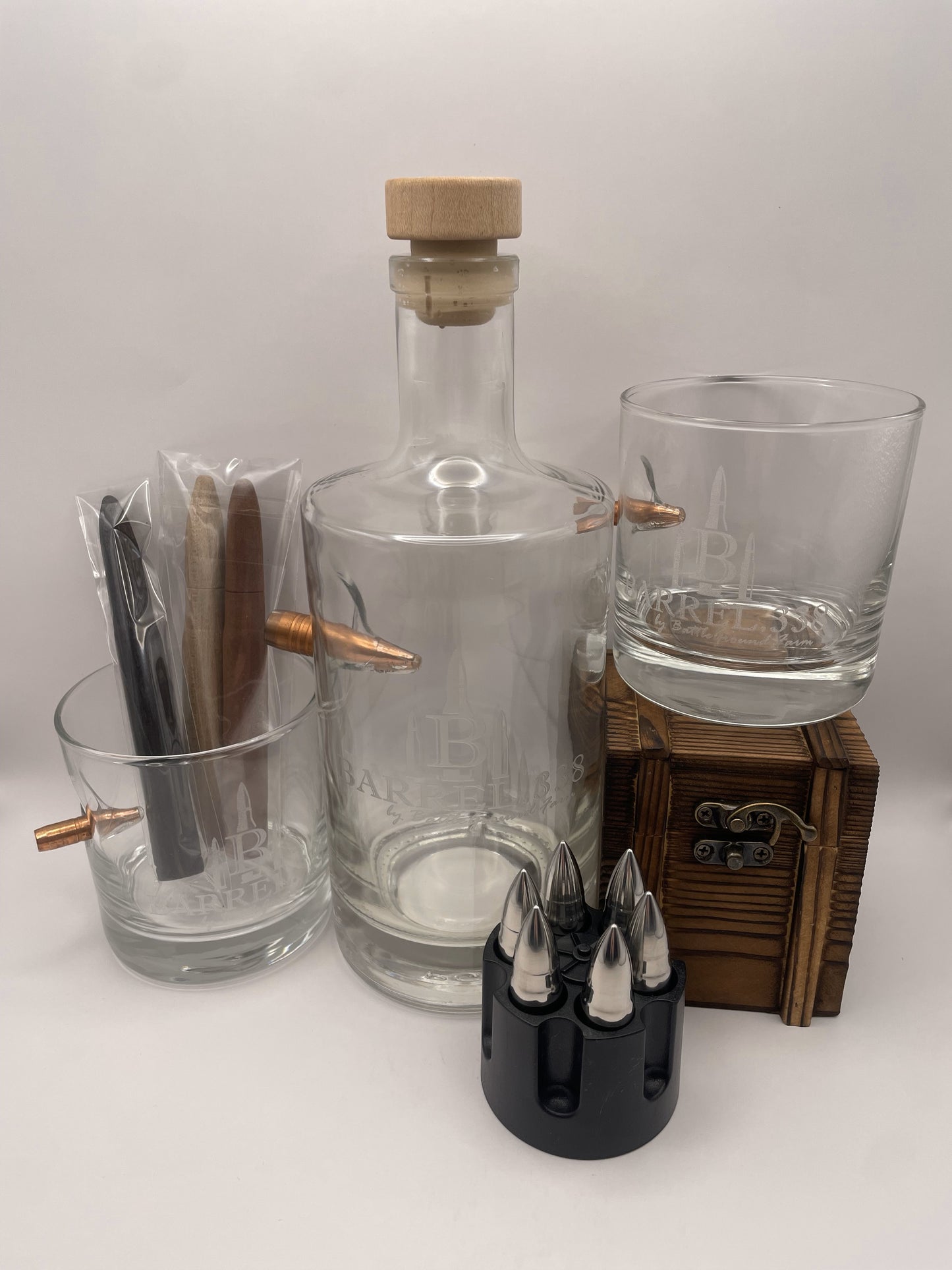 Luxury bourbon gift box with bullet-shaped whiskey stones, two drinking glasses, a glass decanter, and wood infusion sticks for smoothing and aging.