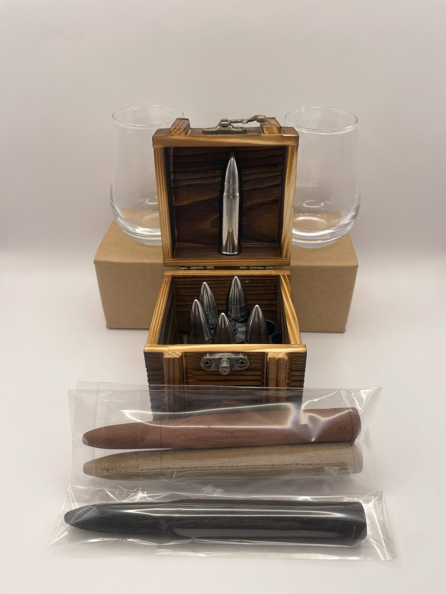 Image of a gift box containing bullet-shaped bourbon chilling stones, two whiskey tasting glasses, and bourbon smoothing and aging infusion staves.