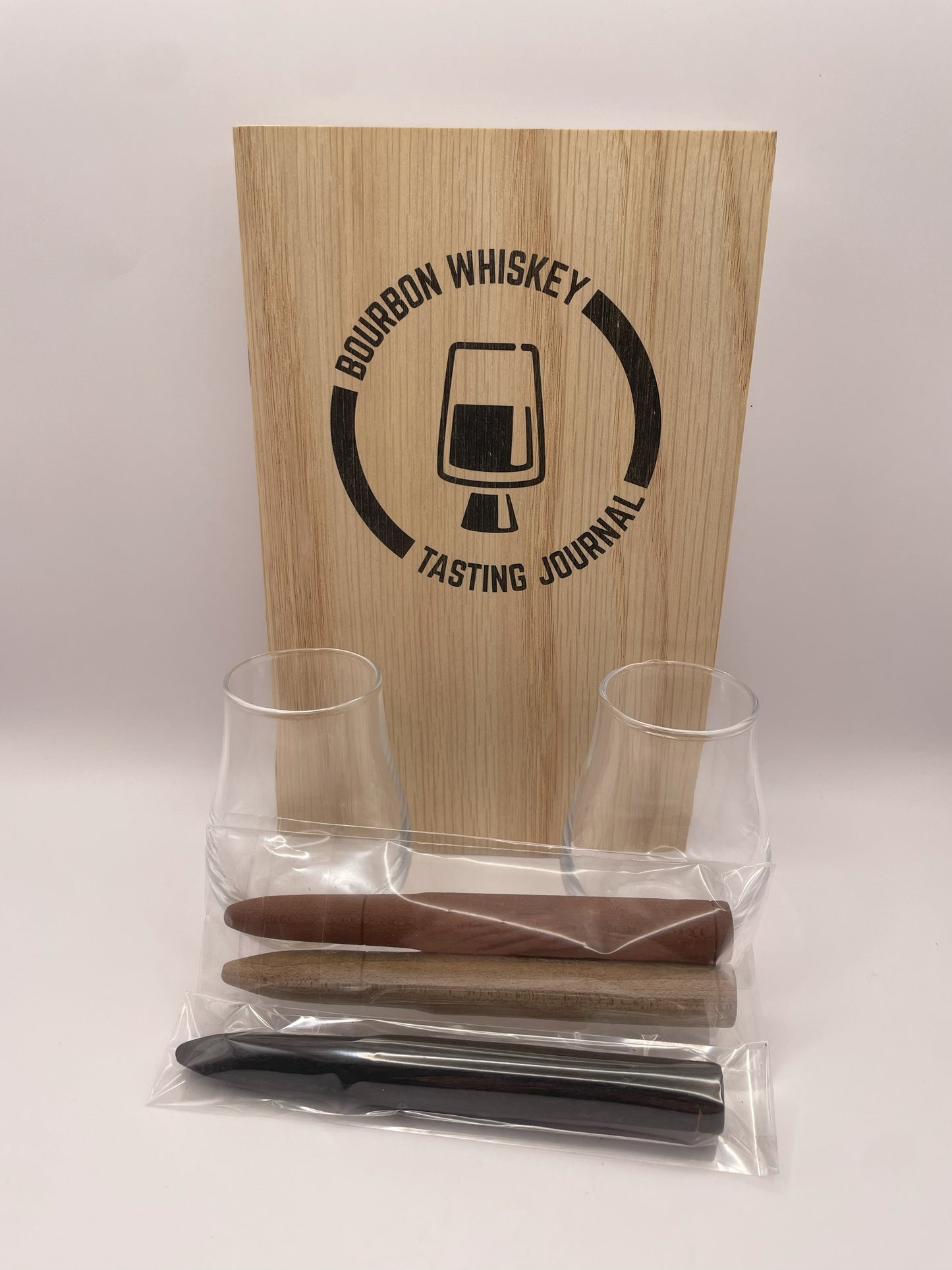 A complete bourbon tasting gift box, including a tasting journal, two elegant tasting glasses, and bourbon smoothing and aging infusion staves.